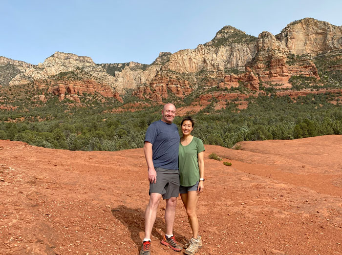 Couple on a hike in front of red rocks in Sedona Arizona
